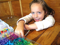 Bead by bead, young girl helps others